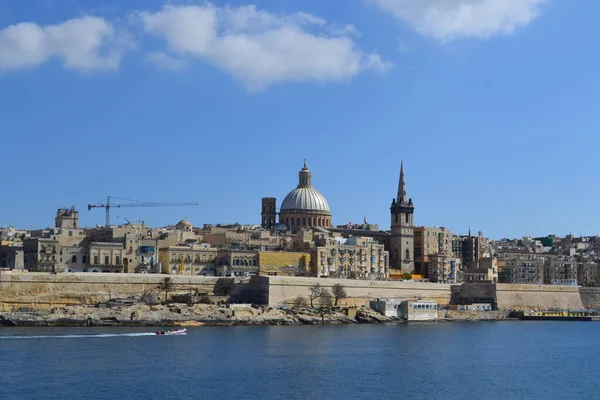 View from above of the golden domes of churches and roofs with church of Our Lady of Mount Carmel and St. Paul's Anglican Pro-Cathedral, Valletta, Capital city of Malta