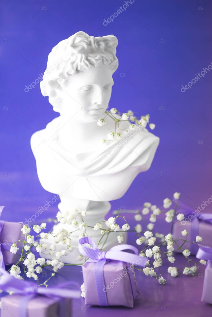 Aesthetics of Ancient Greece, bust with gift boxes of trendy lilac color in neon lighting. The concept of March 8 and Valentines Day