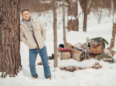 Kış ormanında ateşin yanında bir adam kahve dolduruyor. Yüksek kalite fotoğraf