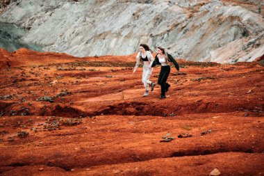 Kıyamet sonrası bir yerde yaşayan kızlar, kırmızı toprağı ve iş kıyafetleri içinde taşlar olan bir taş ocağı. Yüksek kalite fotoğraf