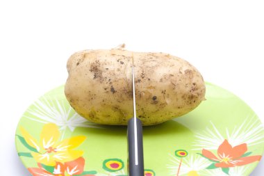 plaka üzerinde bıçak ile büyük bir patates