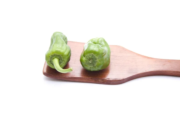 Green Capsicum on wooden spoon — Stock Photo, Image