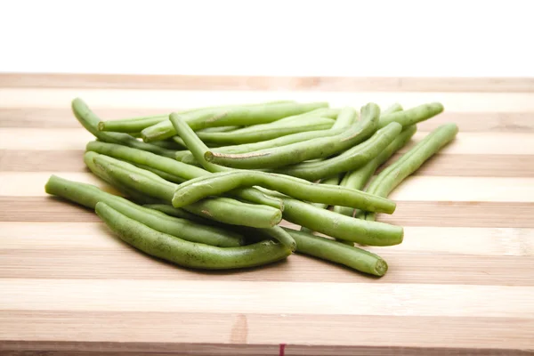 Grüne Saitenbohnen zum Kochen auf Holzteller — Stockfoto