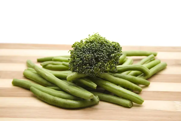 Green Broccoli with Green String beans on wooden plate — Stock Photo, Image