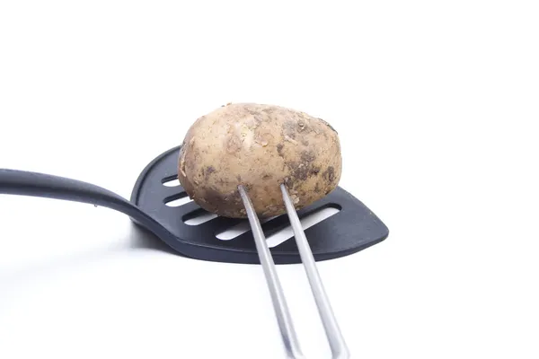 Patatas marrones pinchadas con tenedor de carne —  Fotos de Stock