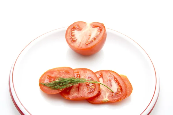 Frische rote Tomate mit Dill auf Plastikteller — Stockfoto