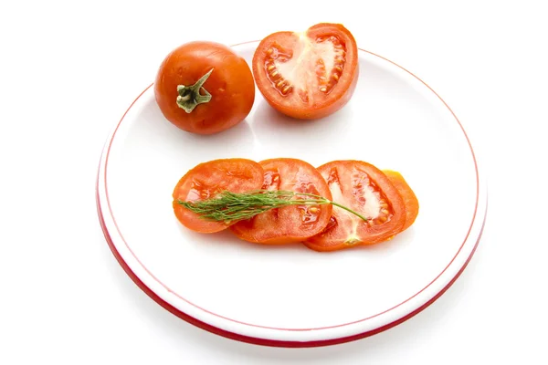 Frische rote Tomate mit Dill auf Plastikteller — Stockfoto