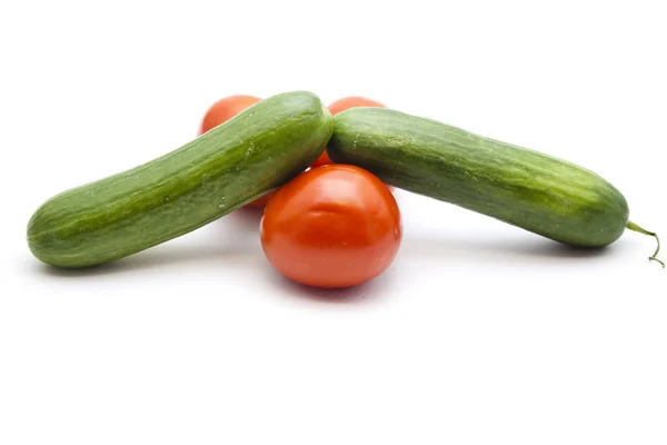 Frische grüne Salatgurken mit roten Tomaten — Stockfoto