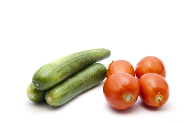Frische grüne Salatgurken mit roten Tomaten — Stockfoto