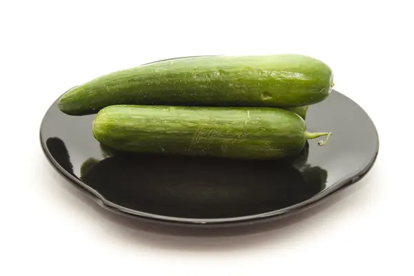 Свіжі зелені огірки на чорній керамічній плиті — стокове фото