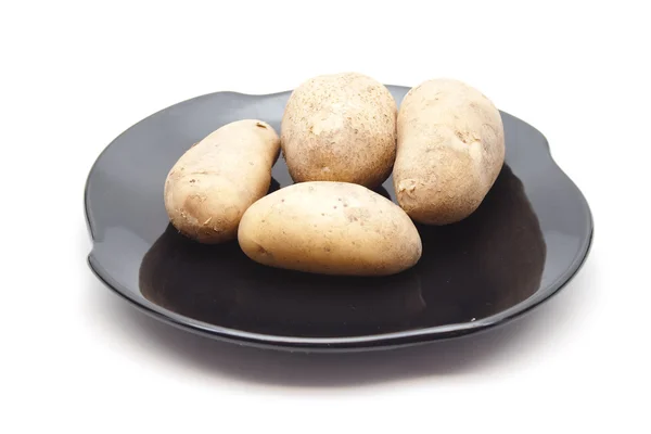 Cartofi proaspeți maro pe plăci ceramice negre — Fotografie, imagine de stoc