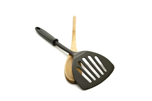 Espátula negra con cuchara de cocina de madera sobre fondo blanco — Foto de Stock
