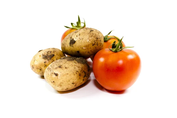 Tomates vermelhos frescos com batatas sobre fundo branco — Fotografia de Stock