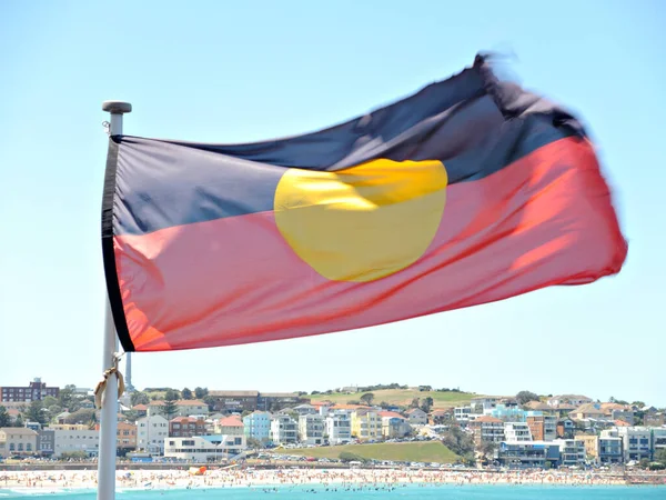 Australia aboriginal flag flying, motion image in windy day, bright sky daybackground.
