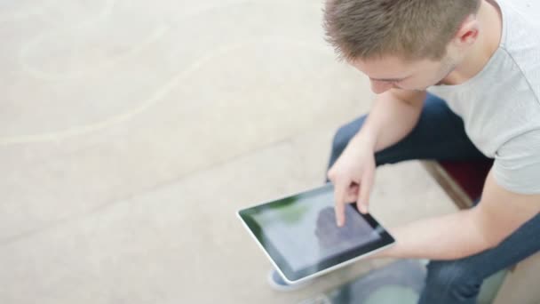 Студент играет с электронным устройством — стоковое видео