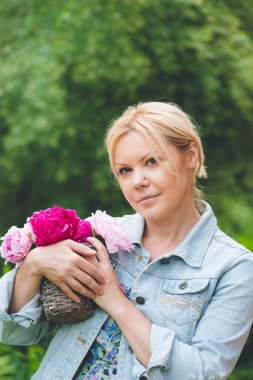 Şakayık çiçekleri olan güzel kadın