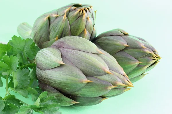 Artichokes on a green background — Stock Photo, Image