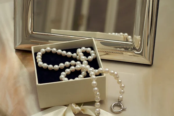 在镜子前面的礼品盒中的珍珠项链 — 图库照片