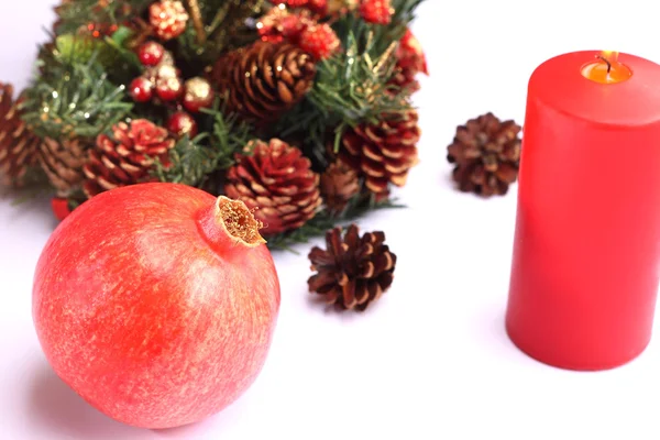 Kerstmis samenstelling granaatappel en Rode kaars — Stockfoto