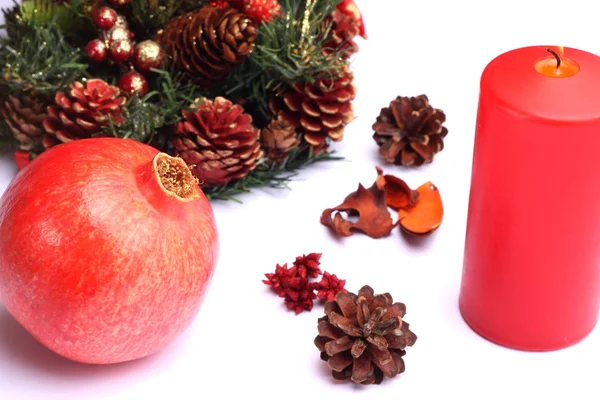 Kerstmis samenstelling granaatappel en Rode kaars — Stockfoto