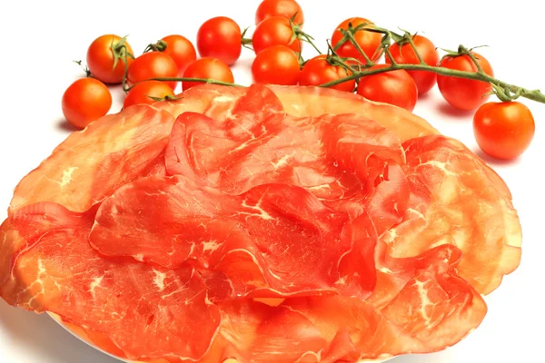 Bresaola with tomatoes on white background — Stock Photo, Image