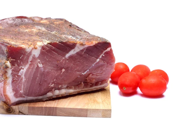 Italienischer Speck auf Holzhackbrett und Tomaten — Stockfoto