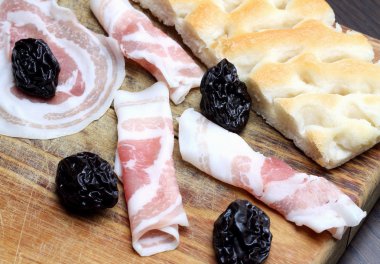 pastırma kuru erik ve elmalı rulo kesme tahtası üzerinde