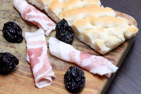 pastırma kuru erik ve elmalı rulo kesme tahtası üzerinde