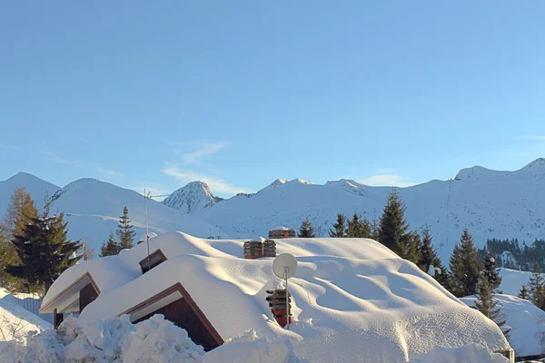 Snow-covered roofs in mountain landscape — Stock Photo, Image