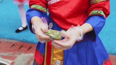 Bir Zhuang kadını Çin Guangxi Zhuang spesiyaliteleri yapıyor, Wormwood keki.
