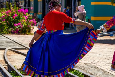 Etnik uzun bir elbise içinde dans eden yaşlı bir kadın.