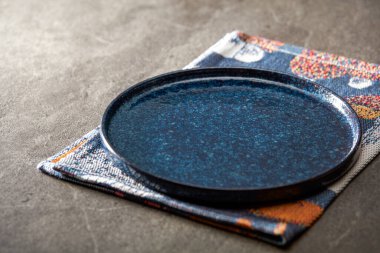 Lüks, boş, mavi bir yemek tabağı mermer bir zemine konur.