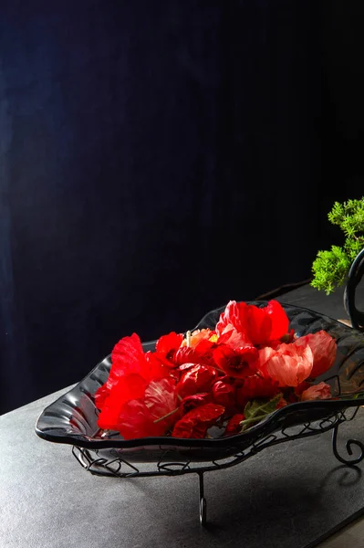 Eine Glasschale Voller Roter Blumen Vor Blauem Lederhintergrund — Stockfoto