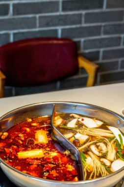 Geleneksel Çin Sichuan güvecinin dibine yakın plan, iki çeşni.