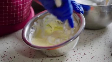 Bir şef kek yapıyor, köpüklü yumurta beyazı karıştırıyor.