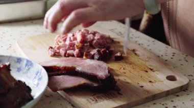 Bir şef char siu bao dolgu yapmak için char siew doğruyor.