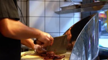 Kanton barbekü dükkanındaki şef taze domuz eti kesip paketliyor.