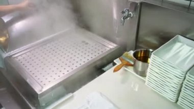 Çin pilav dükkanının mutfağında, şef pirinç rulosu yapıyor.