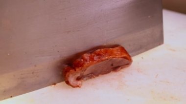 Kanton ağır ateşte pişirilmiş restoranının şefi kızarmış ördek kesiyor ve tavada kızarmış ördek pilavı yapıyor.
