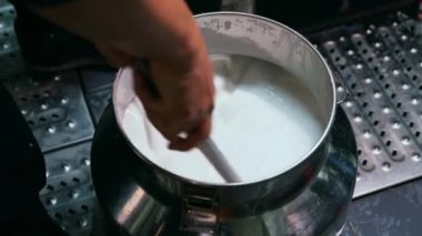 Çin pilav dükkanının mutfağındaki şef pirinç rulosu için pirinç sütü yapıyor.