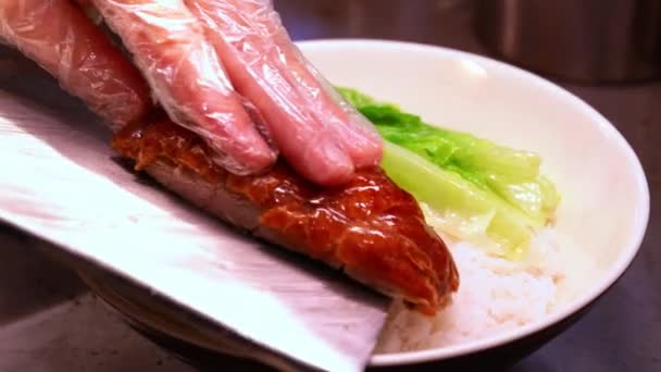 広東風蒸し煮店のシェフが鴨のローストを切り 鴨のローストライスをプレートに盛り付けています — ストック動画