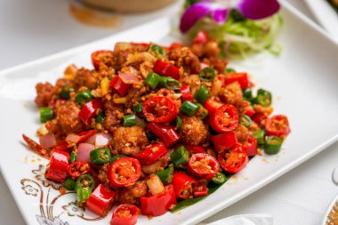 Bir tabak baharatlı ve kızarmış tavuk yanında da çift biber.