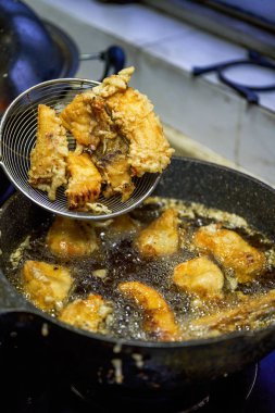 Çinli bir şef kızartma tavasında balık nugget kızartıyor.