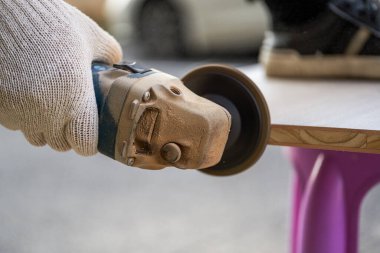 Bir işçi kum diski kesiciyle odun kesiyor.