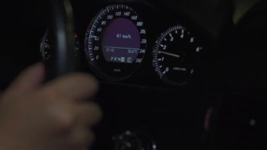 Geceleri hareket halindeki bir arabanın ön paneline yakın plan.