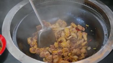A farmhouse restaurant uses a wood-fired earthen pot to make chili fried chicken