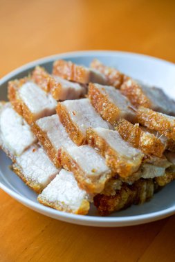 Bir tabak altın ve çekici kızarmış domuz eti ve etle yakın plan.