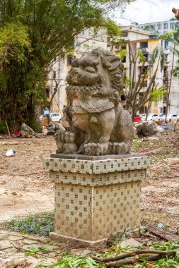 Geleneksel bir Çin bahçesinde yaşlı bir taş aslanın yakın çekimi.