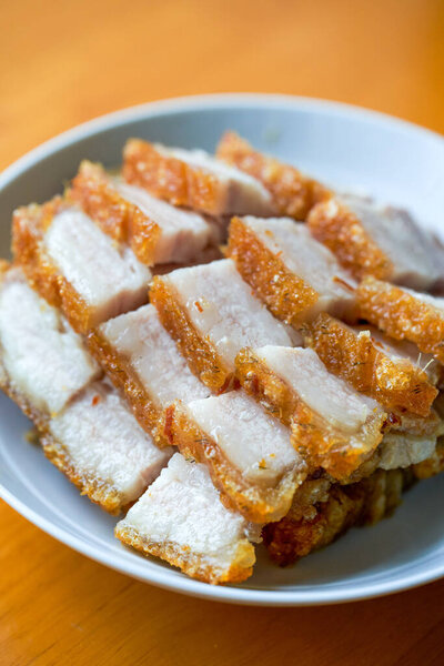 Close-up of a plate of golden and attractive crispy roasted pork, with meat