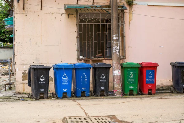 Garbage sorting bins in a residential area. Translation: Other garbage, recyclables.